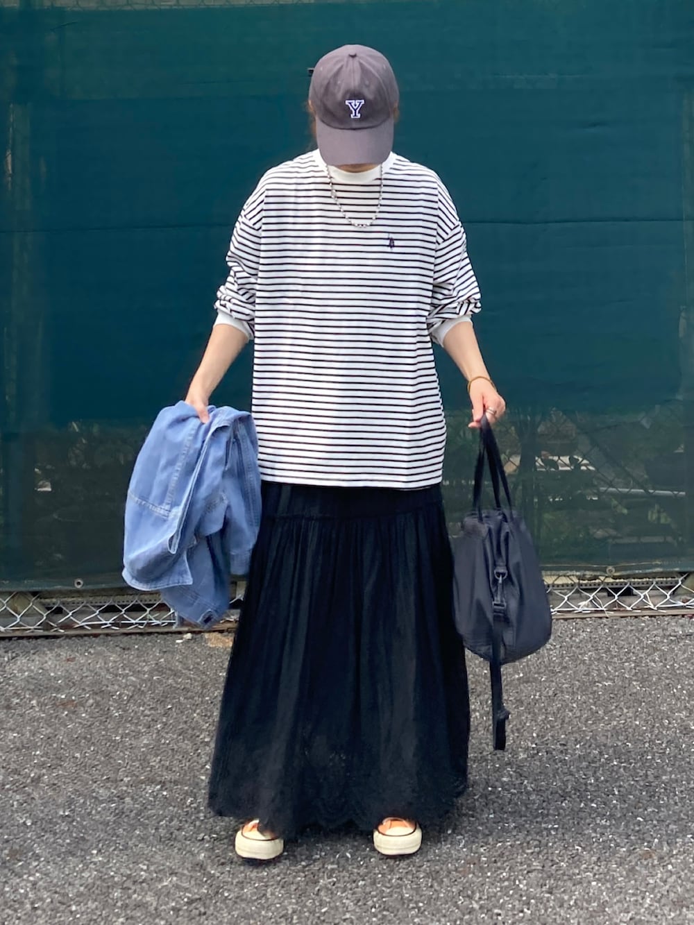 ホワイト系のTシャツ/カットソー、ブラック系のスカート、ブラック系のバッグを着用したレディースの夏コーディネートの4枚目の写真