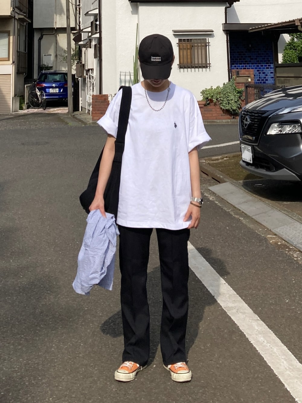 ホワイト系のTシャツ/カットソー、ブルー系のシャツ/ブラウス、ブラック系のショルダーバッグを着用したレディースの春コーディネートの3枚目の写真