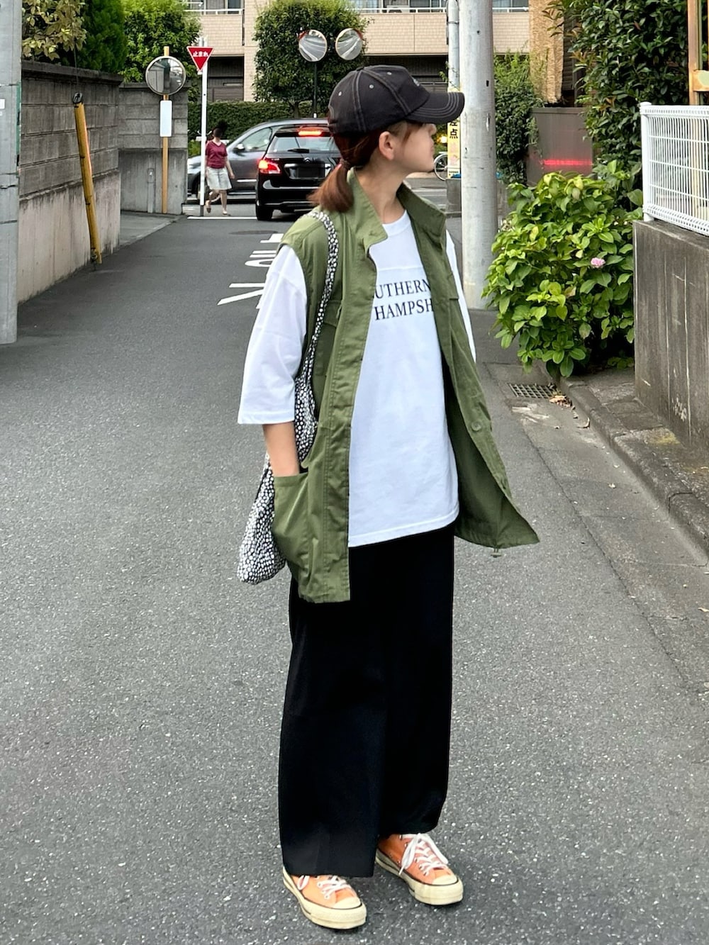 ホワイト系のTシャツ/カットソー、グリーン系のベスト、ブラック系のスカートを着用したレディースの夏コーディネートの2枚目の写真