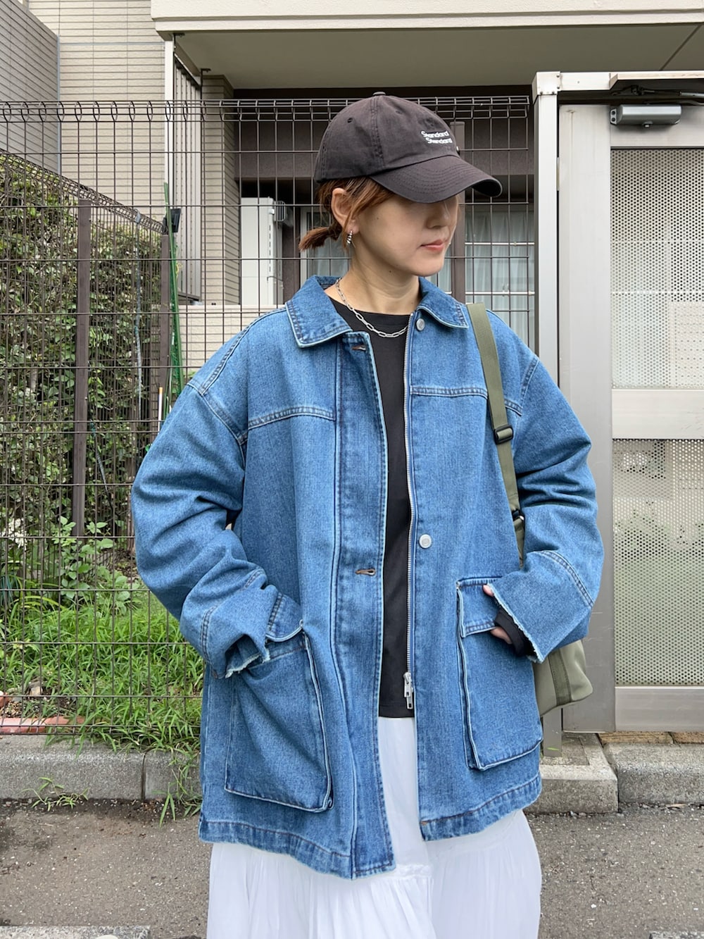 ブラック系のTシャツ/カットソー、ブルー系のデニムジャケット、グリーン系のトートバッグを着用したレディースの秋コーディネートの4枚目の写真