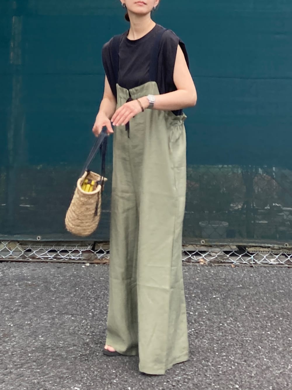グリーン系のサロペット/オーバーオール、ブラック系のかごバッグ、ブラック系のTシャツ/カットソーを着用したレディースの夏コーディネートの2枚目の写真