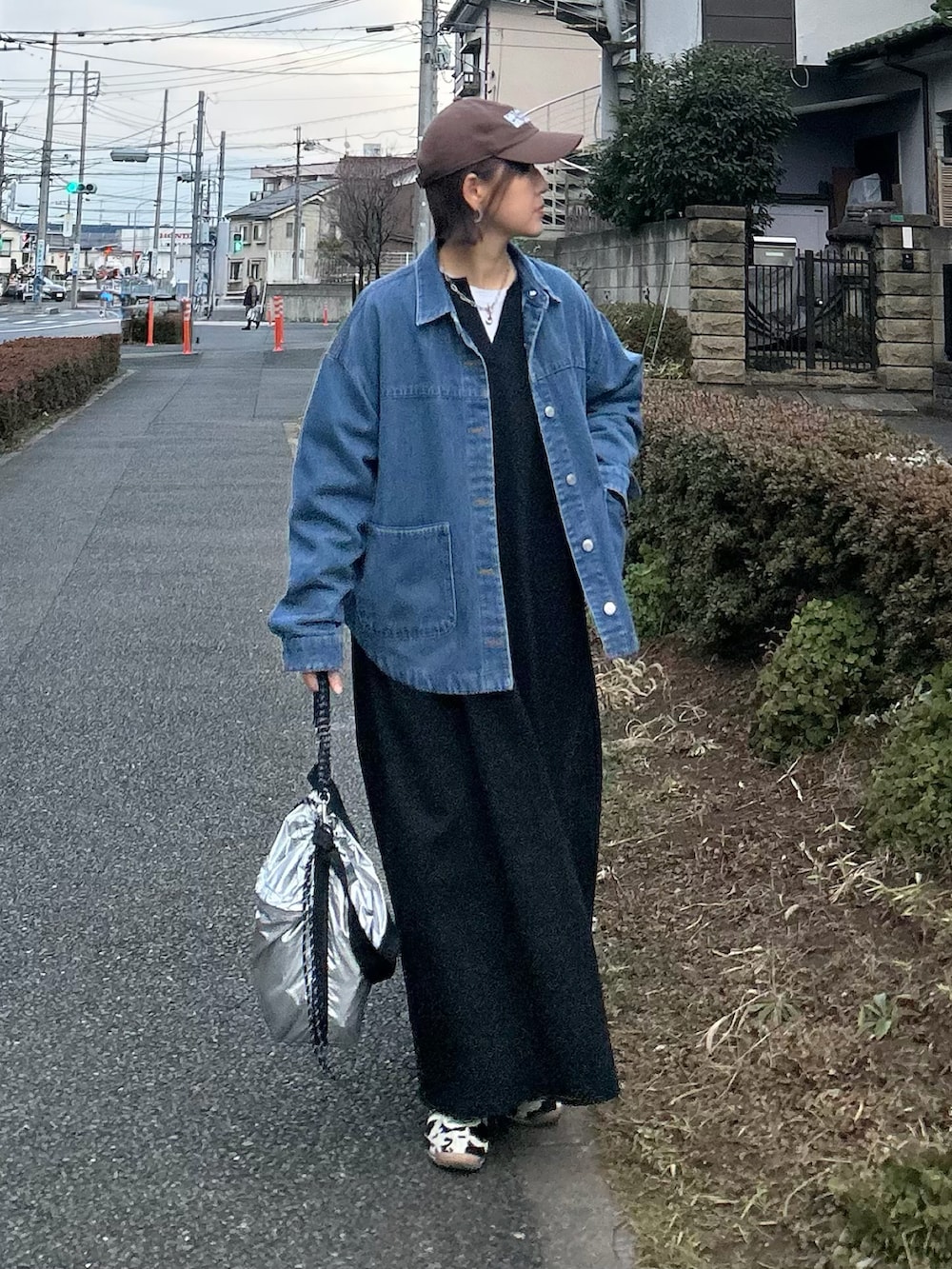 ブルー系のデニムジャケット、ブラック系のワンピース、シルバー系のトートバッグを着用したレディースの春コーディネートの3枚目の写真