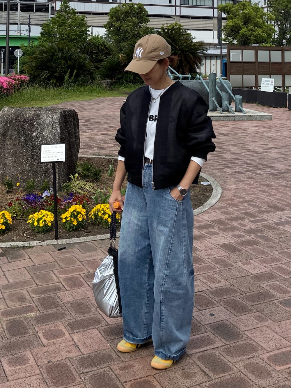 ホワイト系のTシャツ/カットソー、ブラック系のブルゾン、シルバー系のショルダーバッグを着用したレディースの春コーディネートの4枚目の写真