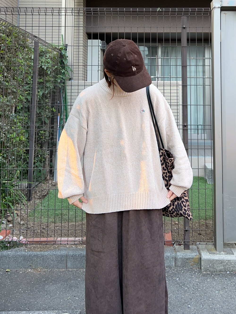 ベージュ系のニット/セーター、ブラウン系のスラックス、ブラウン系のトートバッグを着用したレディースの秋コーディネートの4枚目の写真
