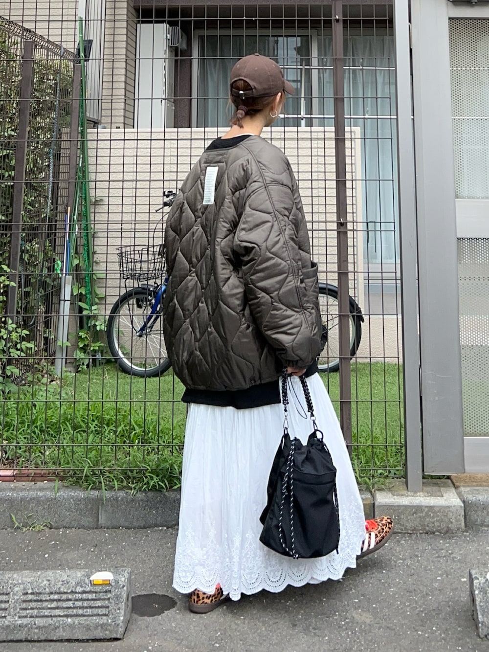 ホワイト系のスカート、ブラック系のトートバッグ、ブラック系のスウェットを着用したレディースの秋コーディネートの5枚目の写真