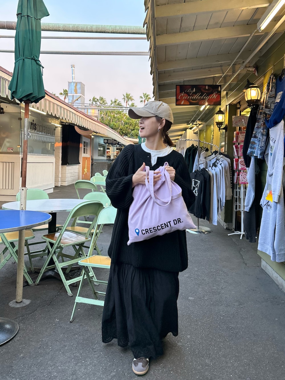 ブラック系のニット/セーター、ブラック系のスカート、パープル系のトートバッグを着用したレディースの冬コーディネートの5枚目の写真