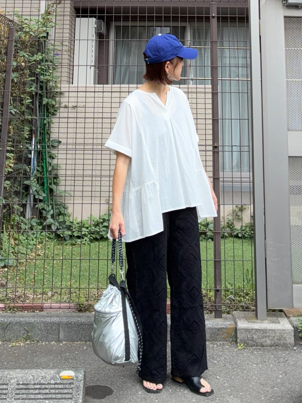 ホワイト系のシャツ/ブラウス、ブラック系のその他パンツ、シルバー系のショルダーバッグを着用したレディースの夏コーディネートの2枚目の写真