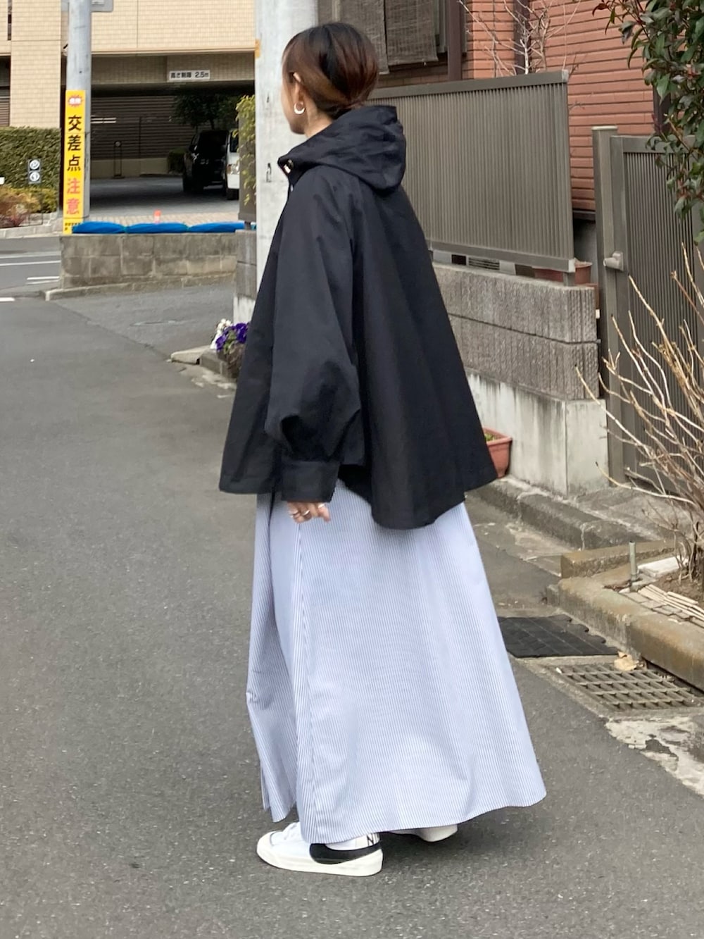 ブラック系のマウンテンパーカー、ブラック系のワンピース、ホワイト系のトートバッグを着用したレディースの冬コーディネートの5枚目の写真