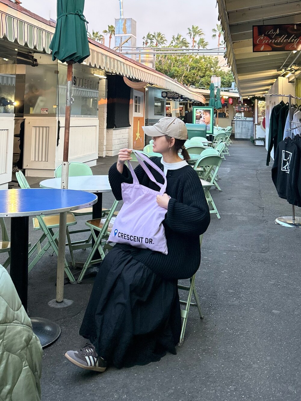 ブラック系のニット/セーター、ブラック系のスカート、パープル系のトートバッグを着用したレディースの冬コーディネートの4枚目の写真