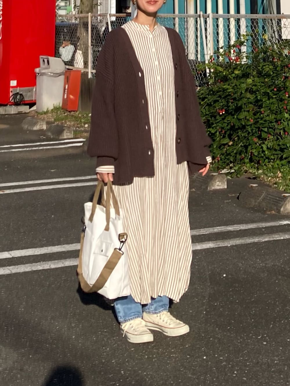 ブラウン系のカーディガン/ボレロ、ホワイト系のトートバッグ、ホワイト系のワンピースを着用したレディースの秋コーディネートの4枚目の写真