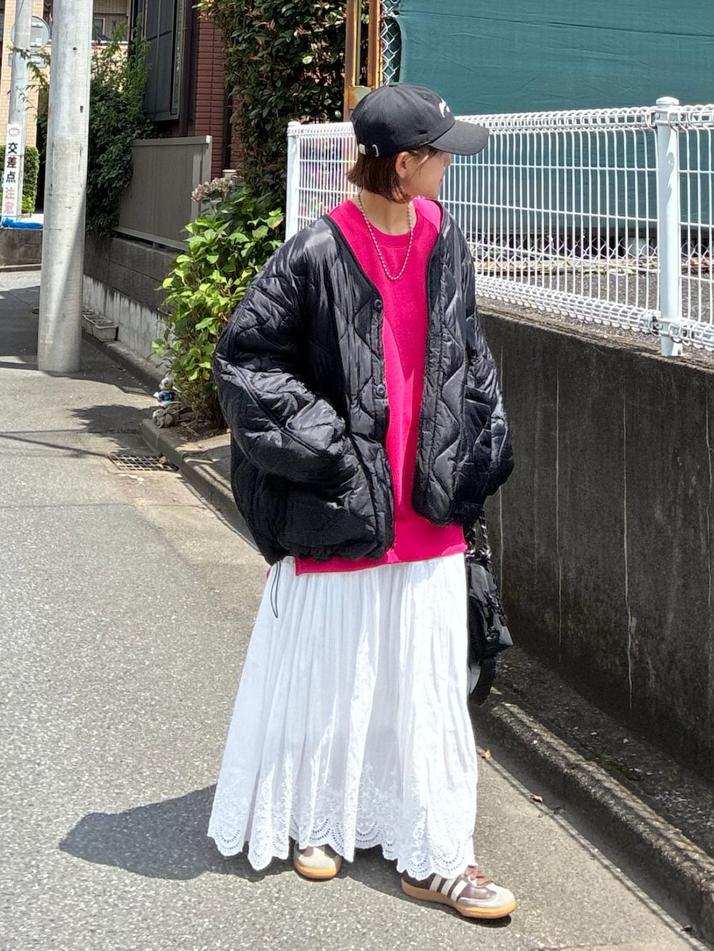 ブラック系のトートバッグ、ブラック系のブルゾン、ブラック系のキャップを着用したレディースの夏コーディネートの3枚目の写真