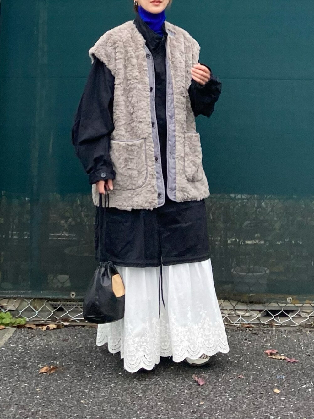 ブラック系のモッズコート、ブルー系のニット/セーター、その他のスニーカーを着用したレディースの冬コーディネートの2枚目の写真