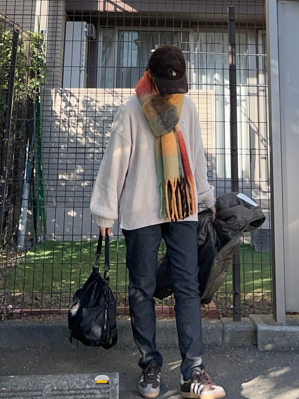 ベージュ系のニット/セーター、ブラック系のその他パンツ、ブラック系のショルダーバッグを着用したレディースの秋コーディネートの2枚目の写真