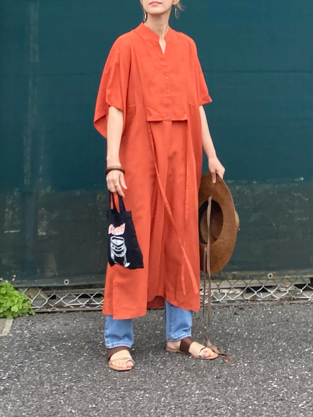 オレンジ系のシャツワンピースを着用したレディースの春コーディネートの4枚目の写真