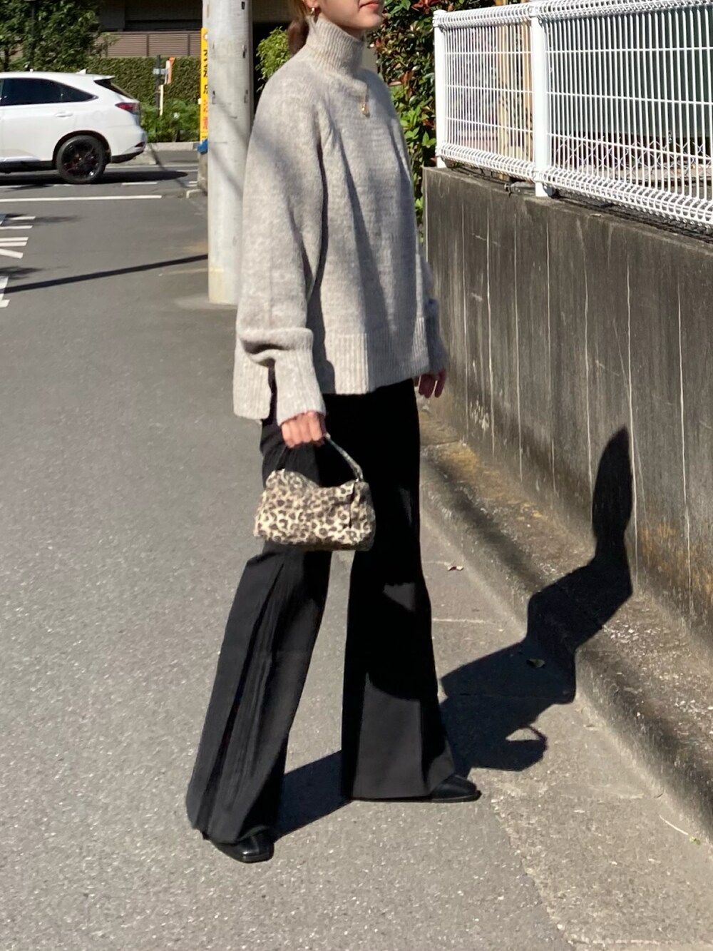 ホワイト系のニット/セーター、ブラック系のその他パンツ、ブラック系のブーツを着用したレディースの秋コーディネートの5枚目の写真