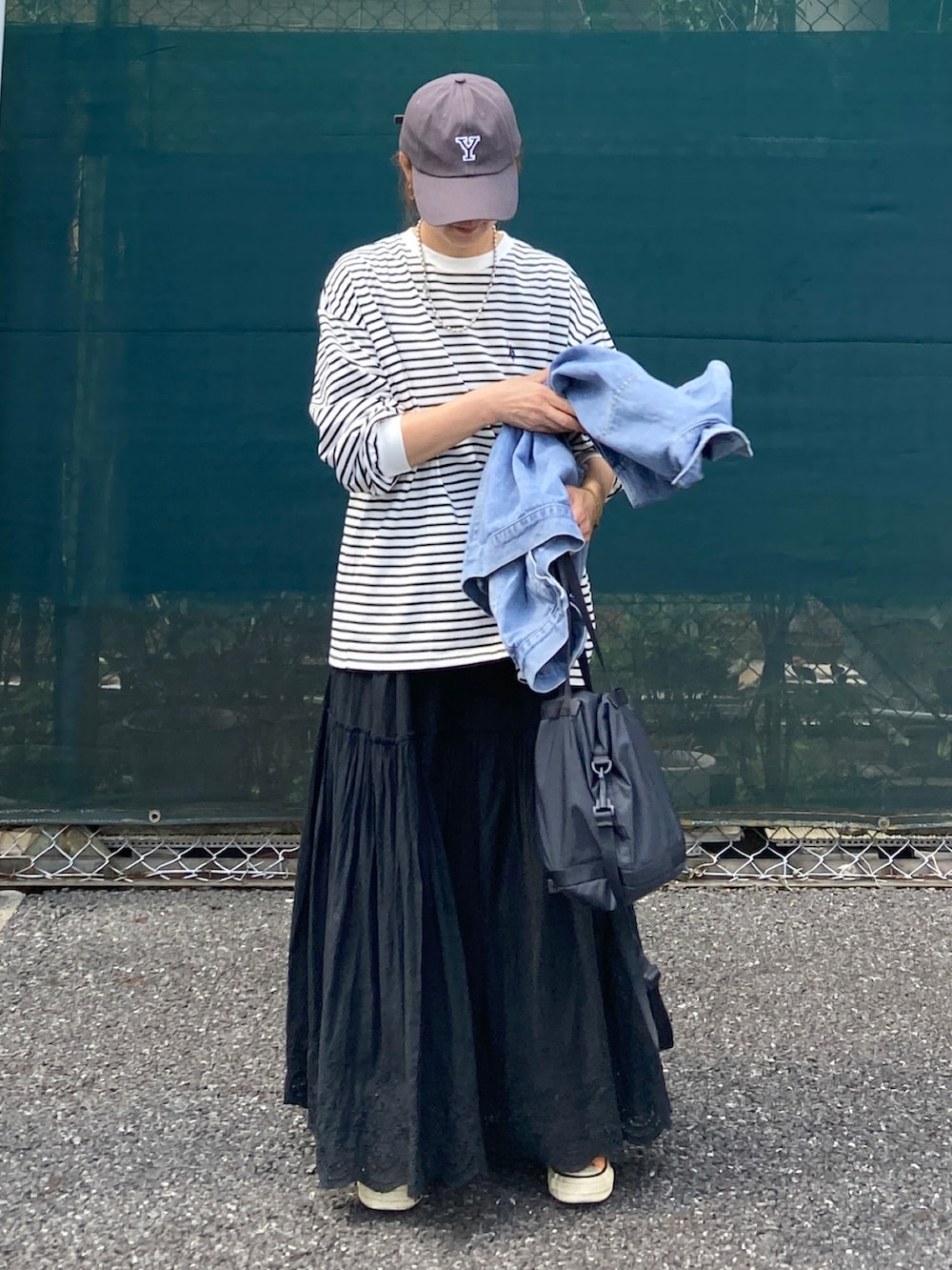 ホワイト系のTシャツ/カットソー、ブラック系のスカート、ブラック系のバッグを着用したレディースの夏コーディネートの5枚目の写真