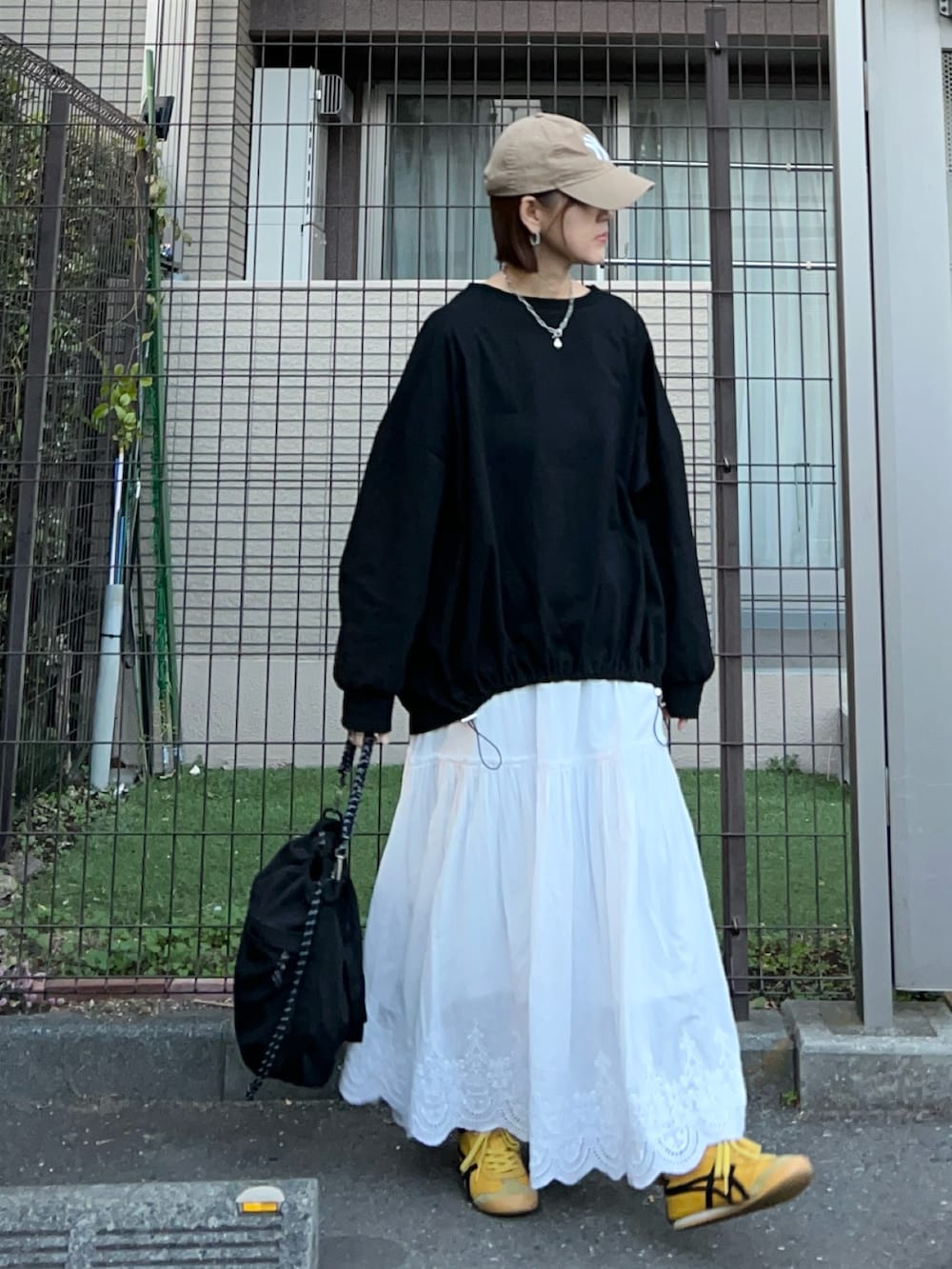 ホワイト系のスカート、シルバー系のトートバッグ、ブラック系のTシャツ/カットソーを着用したレディースの冬コーディネートの5枚目の写真