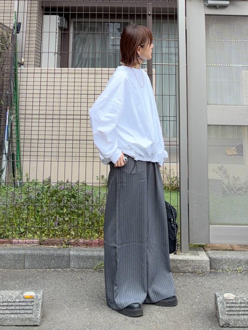 ホワイト系のTシャツ/カットソー、グレー系のその他パンツ、ブラック系のトートバッグを着用したレディースの春コーディネートの2枚目の写真