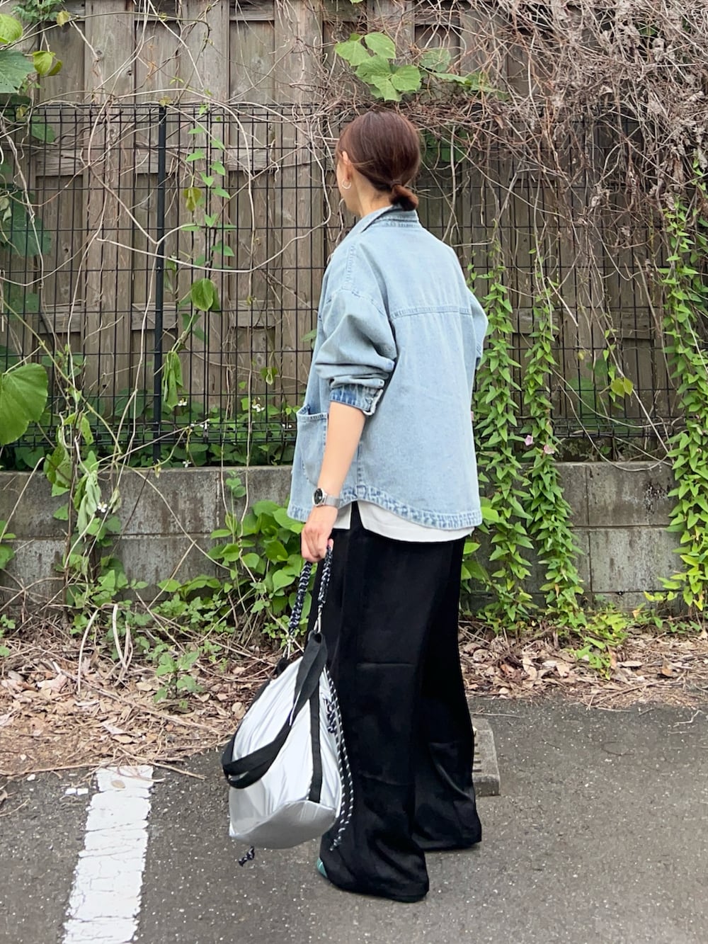 ブルー系のデニムジャケット、ホワイト系のTシャツ/カットソー、ブラック系のその他パンツを着用したレディースの春コーディネートの3枚目の写真