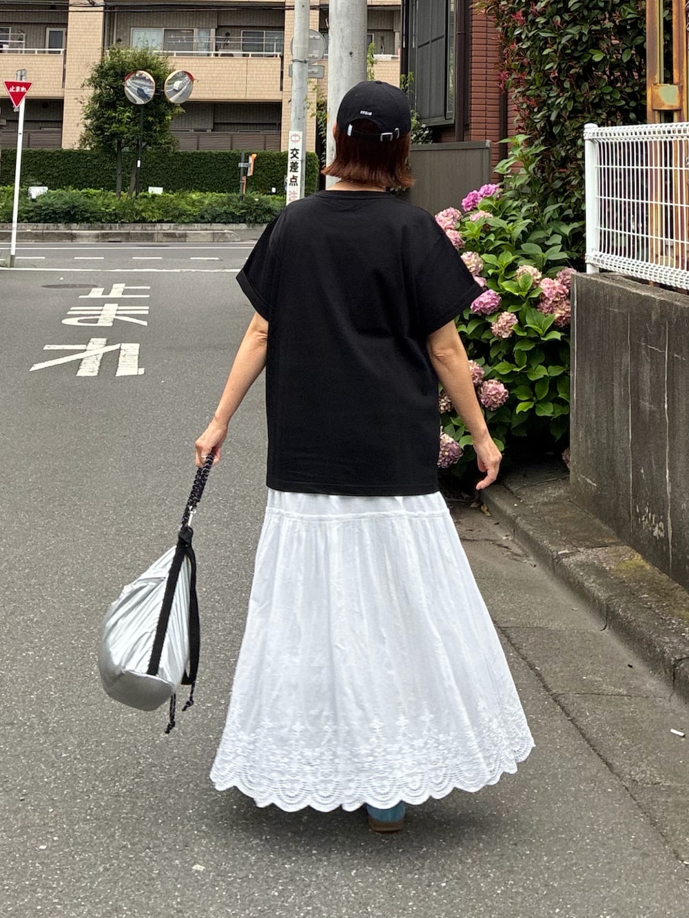 ブラック系のTシャツ/カットソー、ホワイト系のスカート、シルバー系のショルダーバッグを着用したレディースの夏コーディネートの4枚目の写真