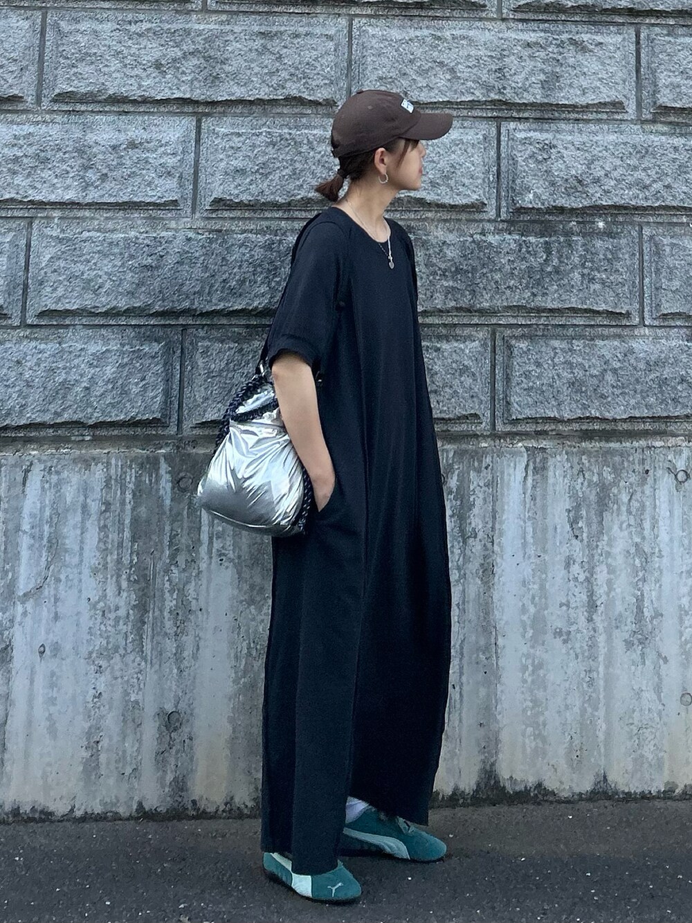 ブラック系のワンピース、シルバー系のトートバッグ、グリーン系のスニーカーを着用したレディースの夏コーディネートの2枚目の写真