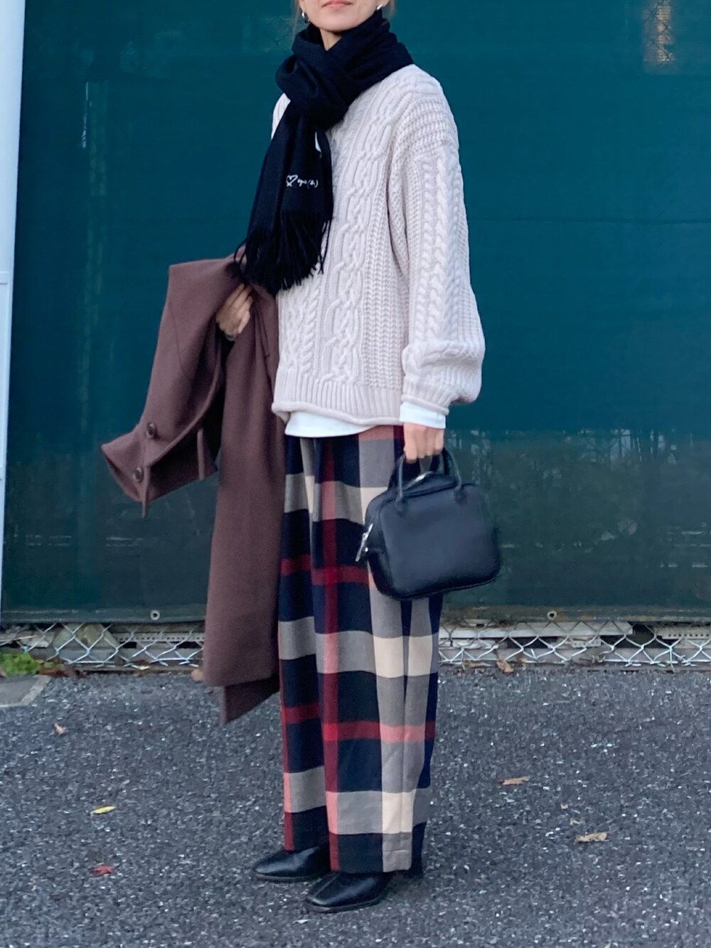 ベージュ系のニット/セーター、ブルー系のその他パンツ、ブラック系のボストンバッグを着用したレディースの冬コーディネートの3枚目の写真