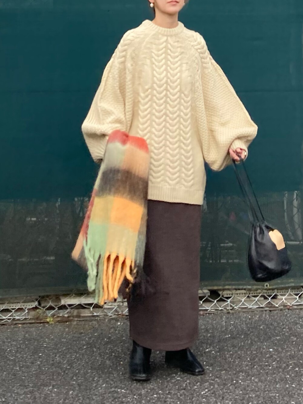 ホワイト系のニット/セーター、ブラウン系のスカート、ブラック系のハンドバッグを着用したレディースの冬コーディネートの5枚目の写真