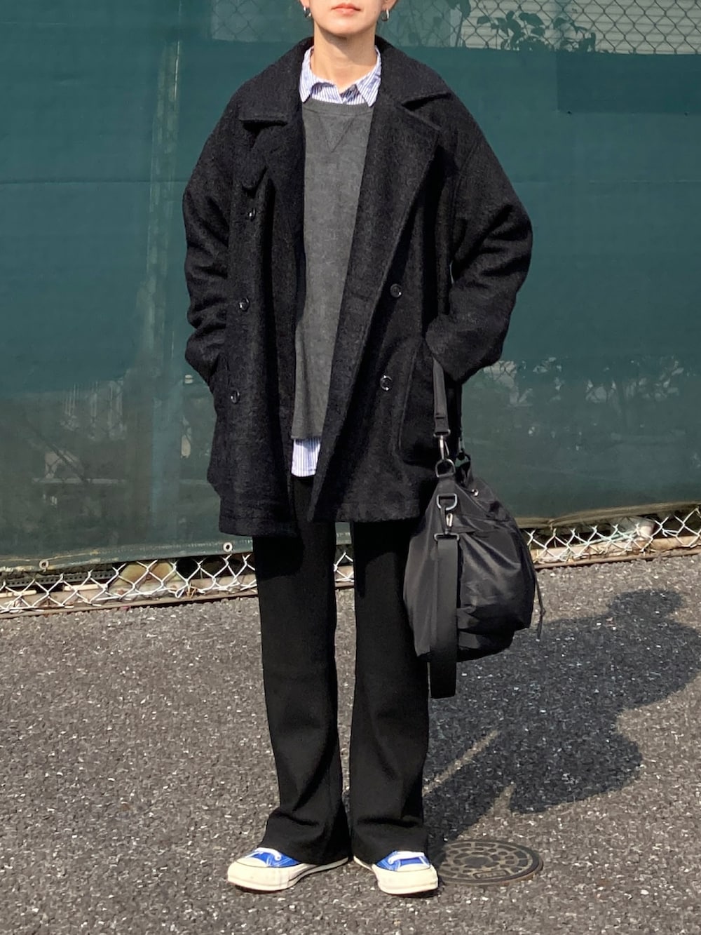 ブラック系のピーコート、グレー系のニット/セーター、ブルー系のシャツ/ブラウスを着用したレディースの秋コーディネートの2枚目の写真