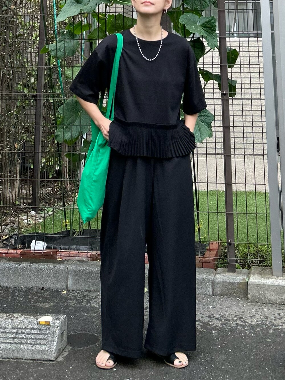 ブラック系のTシャツ/カットソー、ブラック系のその他パンツ、グリーン系のトートバッグを着用したレディースの夏コーディネートの2枚目の写真