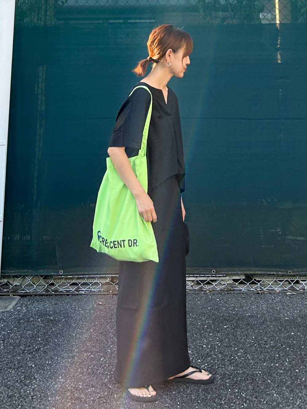 ブラック系のTシャツ/カットソー、ブラック系のスカート、グリーン系のトートバッグを着用したレディースの夏コーディネートの5枚目の写真