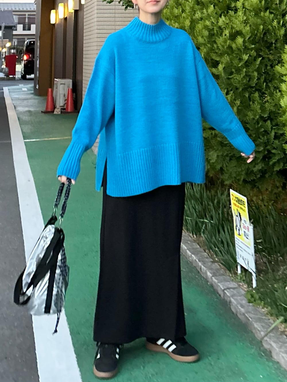 ブルー系のニット/セーター、ブラック系のスカート、シルバー系のトートバッグを着用したレディースの冬コーディネートの4枚目の写真