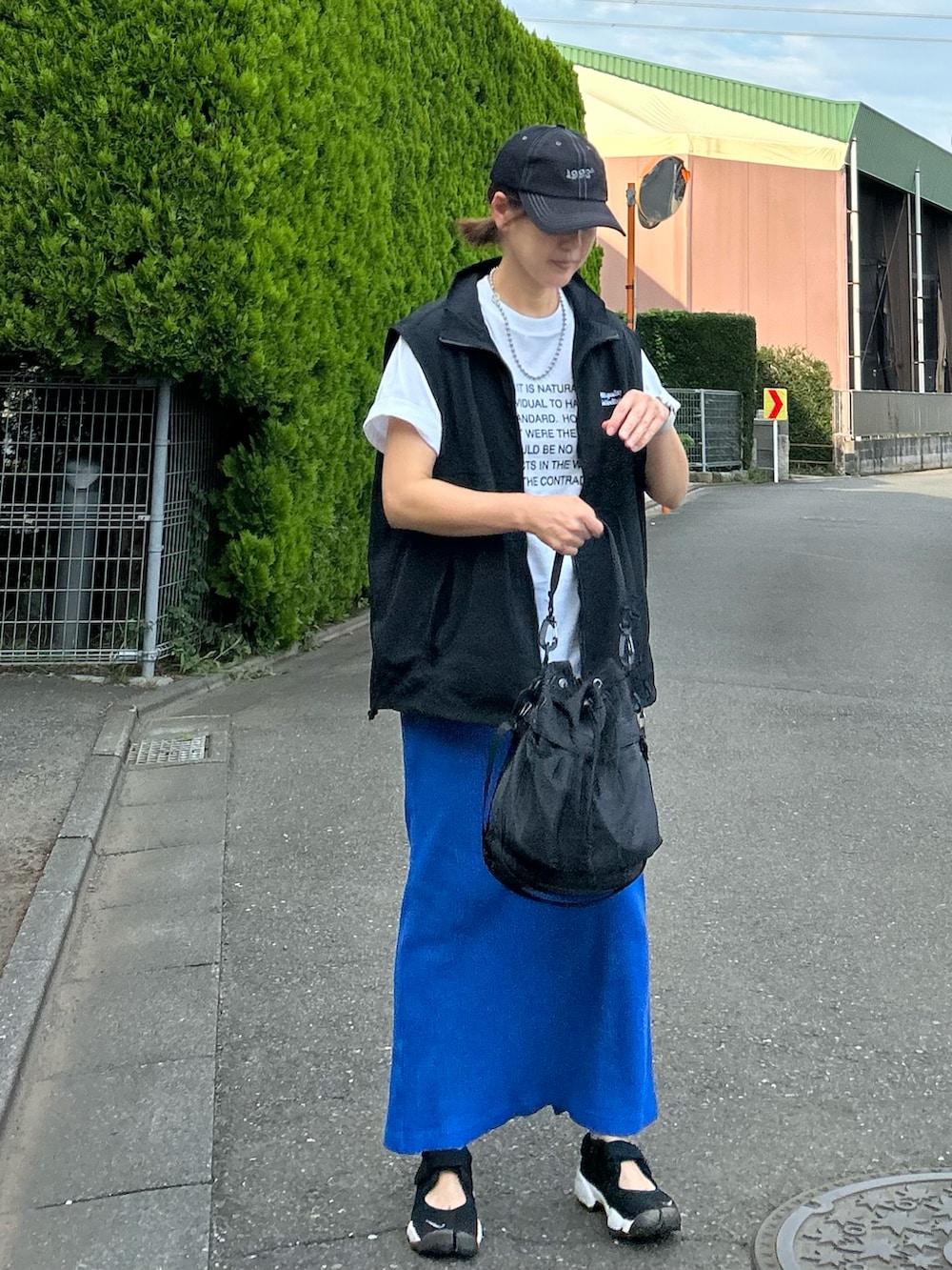 ホワイト系のTシャツ/カットソー、ブラック系のベスト、ブルー系のスカートを着用したレディースの夏コーディネートの3枚目の写真