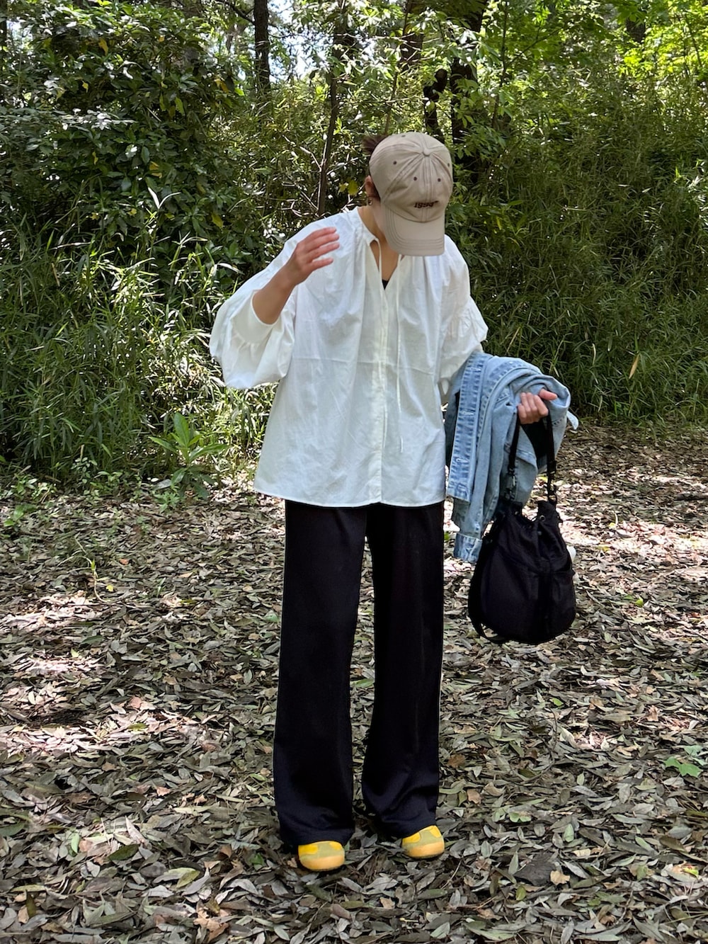 ホワイト系のシャツ/ブラウス、ブラック系のスラックス、ブラック系のショルダーバッグを着用したレディースの春コーディネートの3枚目の写真