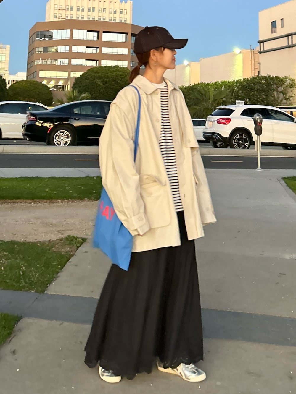 ホワイト系のブルゾン、ホワイト系のTシャツ/カットソー、ブラック系のスカートを着用したレディースの冬コーディネートの5枚目の写真