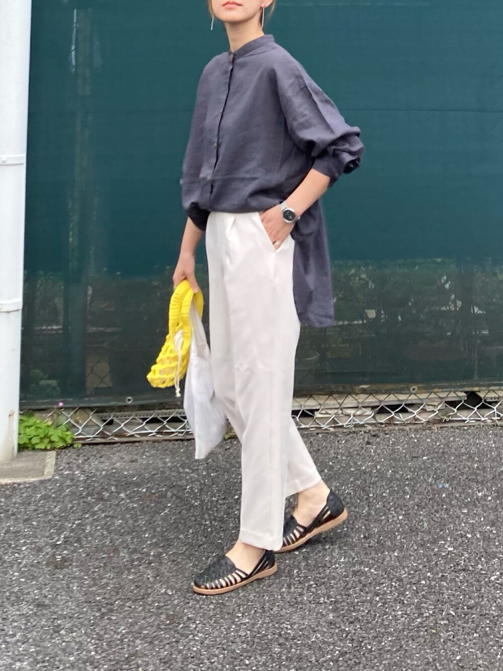グレー系のシャツ/ブラウス、ホワイト系のスラックス、イエロー系のハンドバッグを着用したレディースの春コーディネートの3枚目の写真