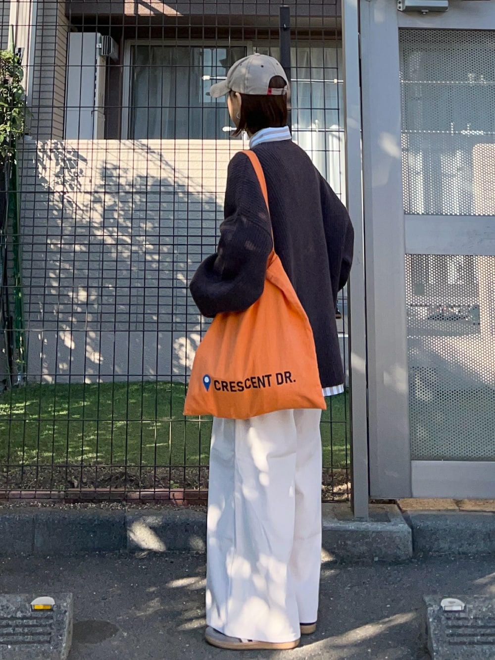 ブラウン系のニット/セーター、ベージュ系のシャツ/ブラウス、ホワイト系のその他パンツを着用したレディースの春コーディネートの2枚目の写真