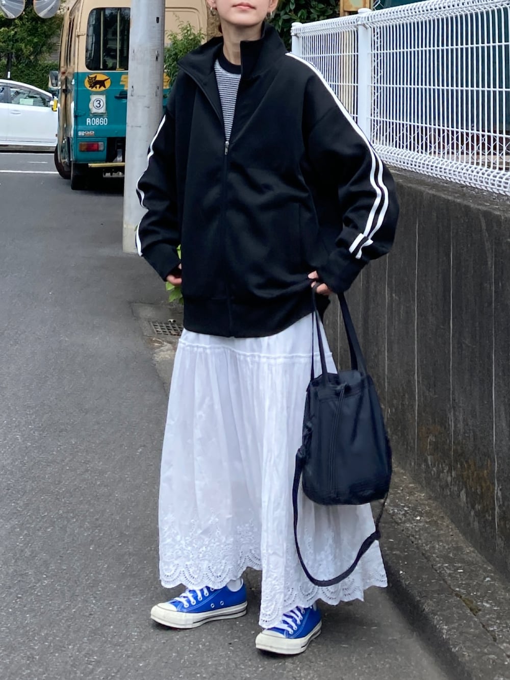 ブラック系のジャージ、ホワイト系のTシャツ/カットソー、ホワイト系のスカートを着用したレディースの夏コーディネートの2枚目の写真