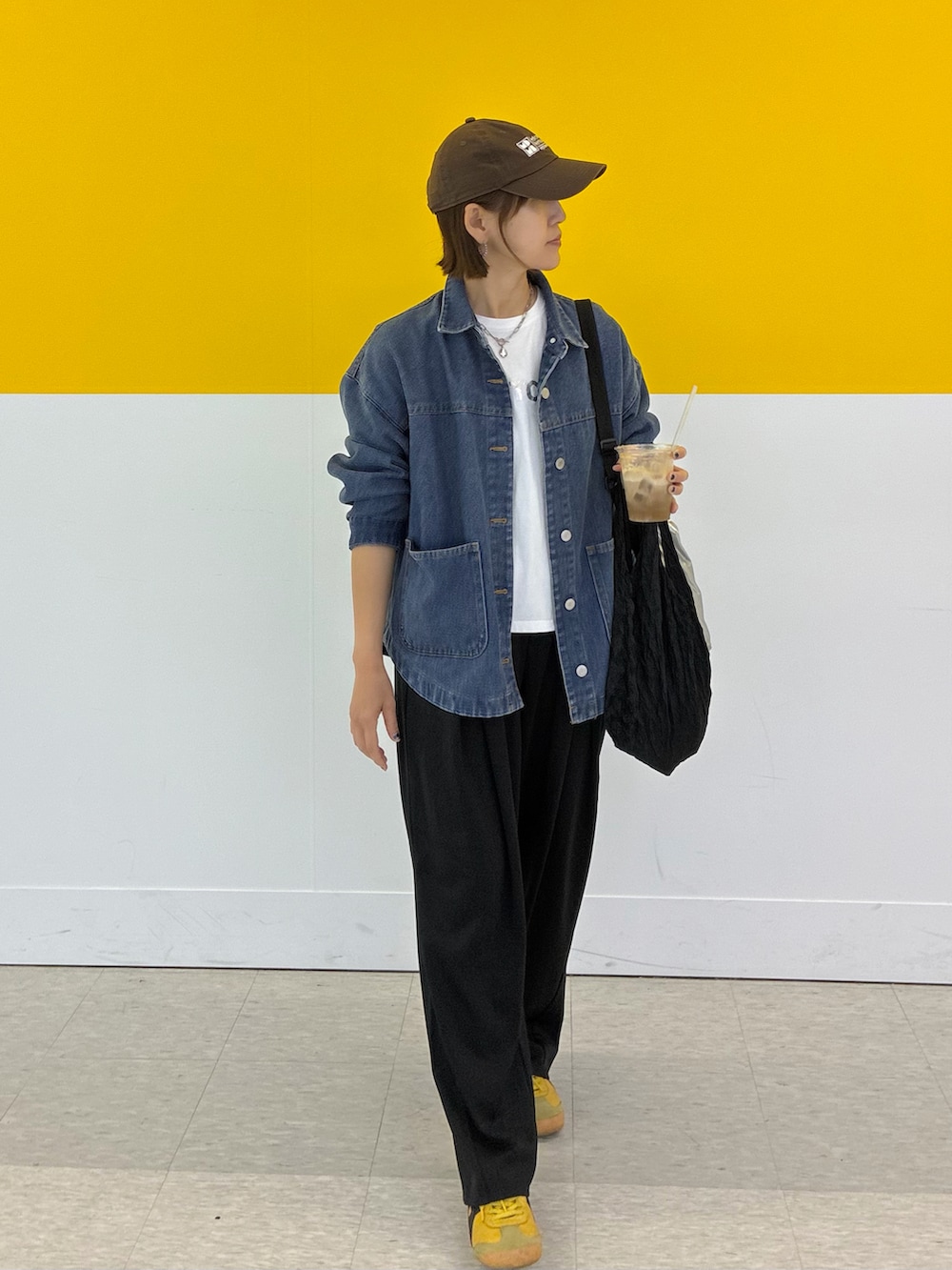 ブラック系のスラックス、ブルー系のデニムジャケット、ホワイト系のTシャツ/カットソーを着用したレディースの春コーディネートの5枚目の写真