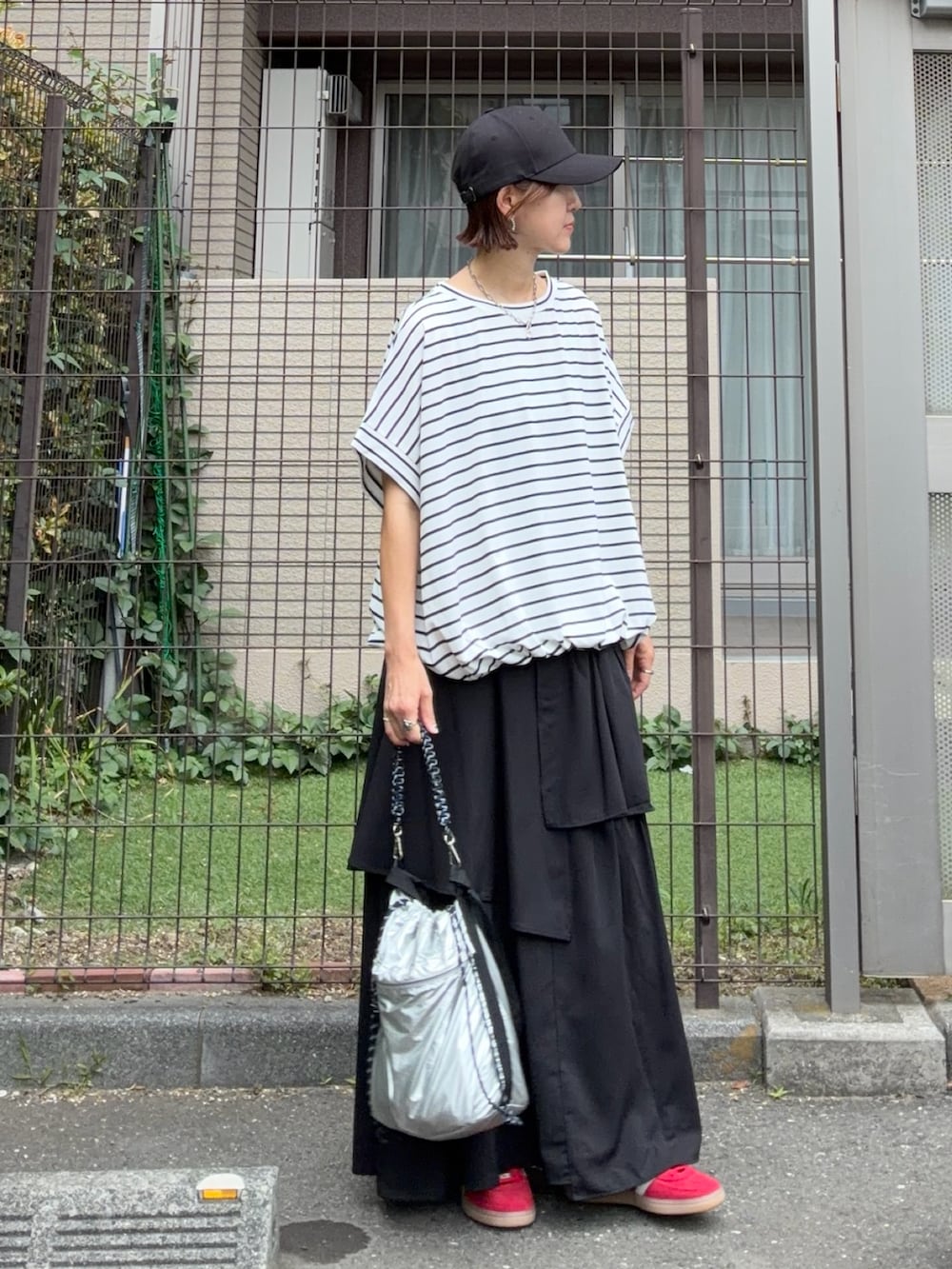 ブラック系のスカート、シルバー系のショルダーバッグ、ホワイト系のTシャツ/カットソーを着用したレディースの春コーディネートの3枚目の写真