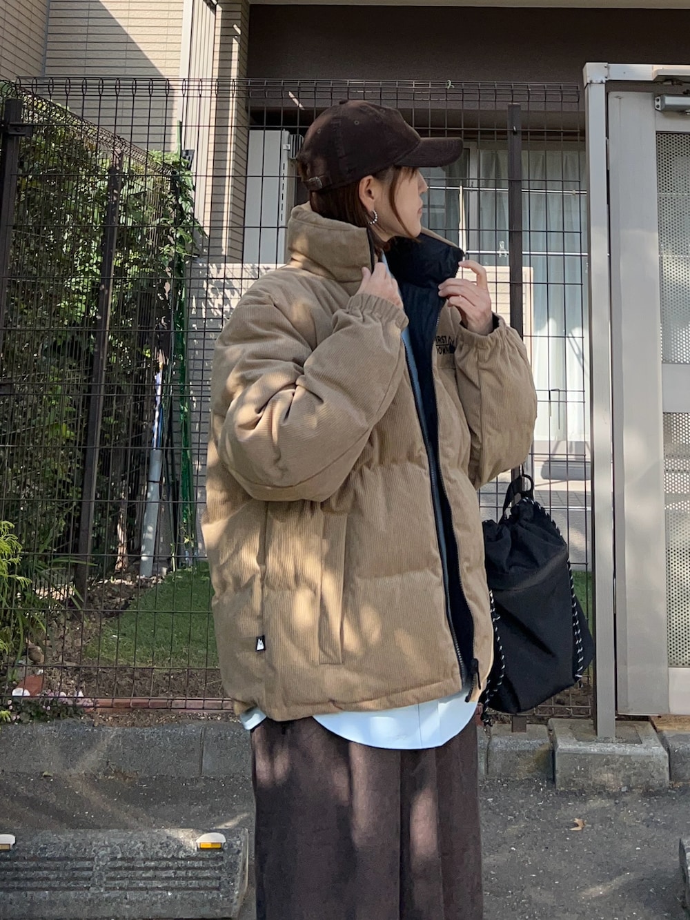 ベージュ系のダウンジャケット/コート、ブラウン系のスラックス、ブラック系のトートバッグを着用したレディースの冬コーディネートの3枚目の写真