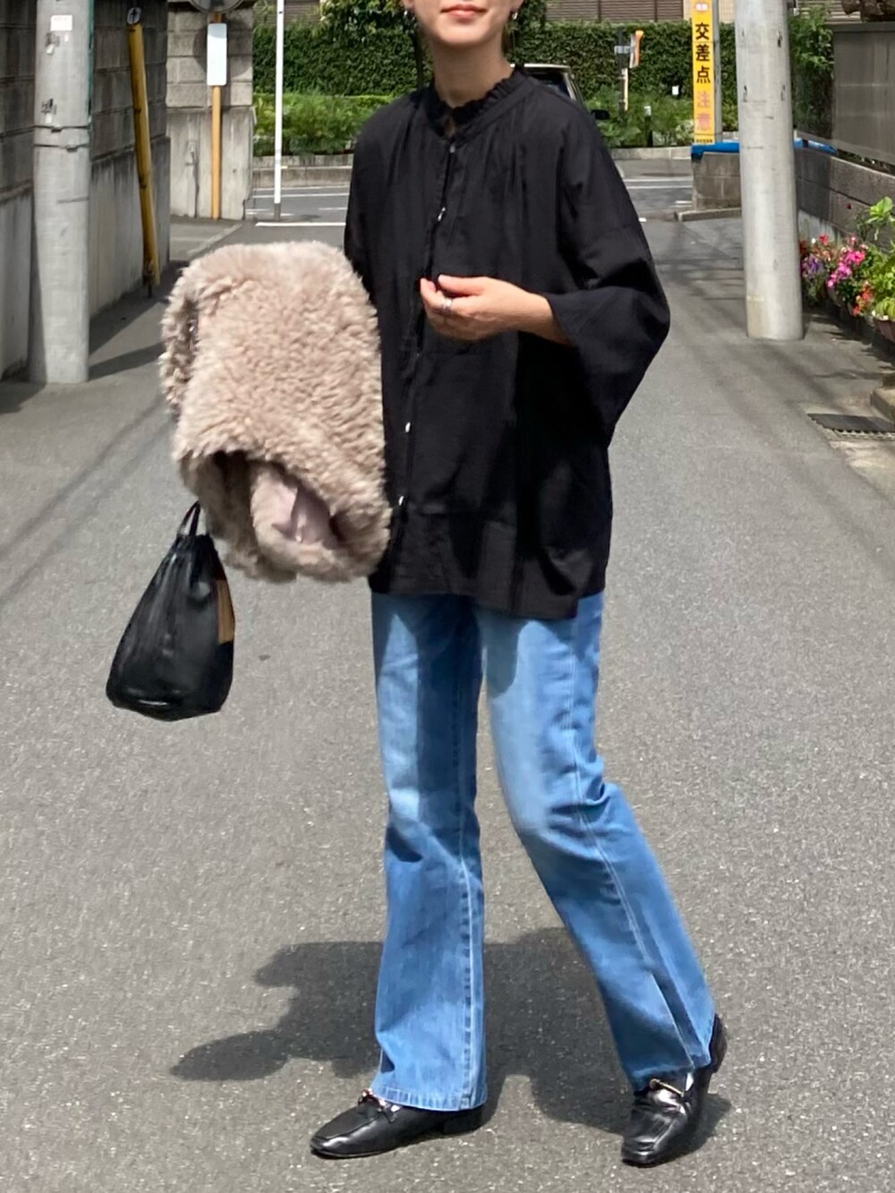 ブラック系のシャツ/ブラウス、ブルー系のデニムパンツ、ベージュ系のベストを着用したレディースの秋コーディネートの4枚目の写真
