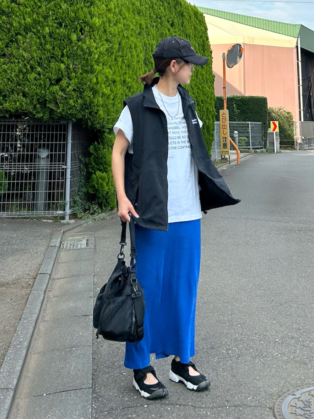 ホワイト系のTシャツ/カットソー、ブラック系のベスト、ブルー系のスカートを着用したレディースの夏コーディネートの2枚目の写真