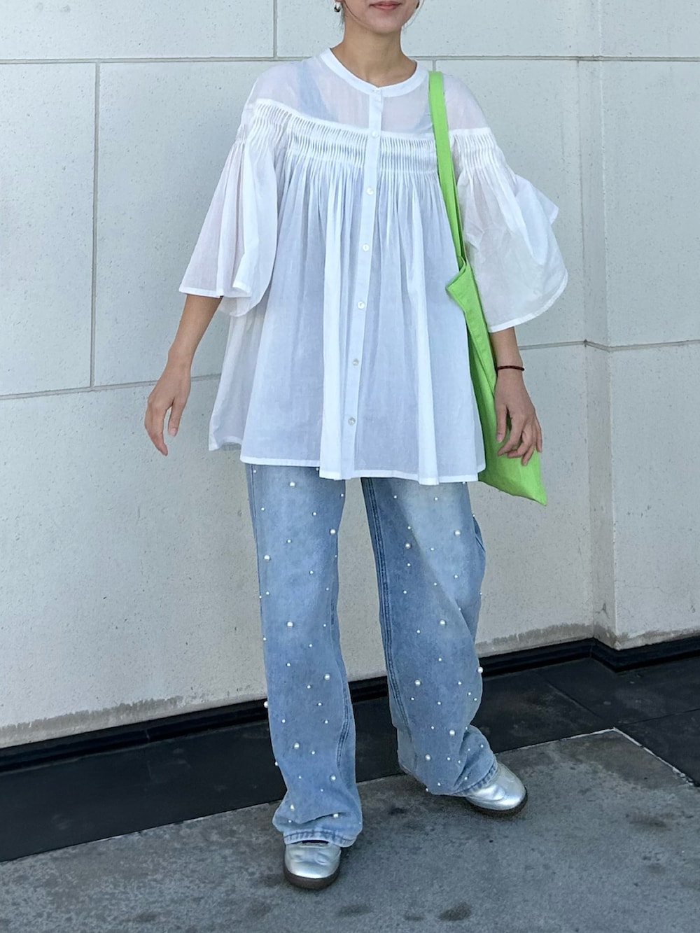 ホワイト系のシャツ/ブラウス、グリーン系のトートバッグ、シルバー系のスニーカーを着用したレディースの春コーディネートの4枚目の写真
