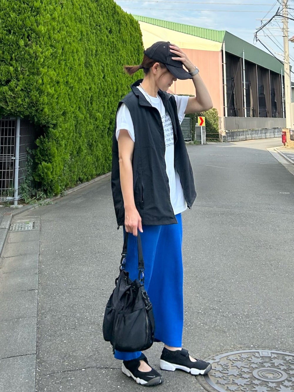 ホワイト系のTシャツ/カットソー、ブラック系のベスト、ブルー系のスカートを着用したレディースの夏コーディネートの4枚目の写真