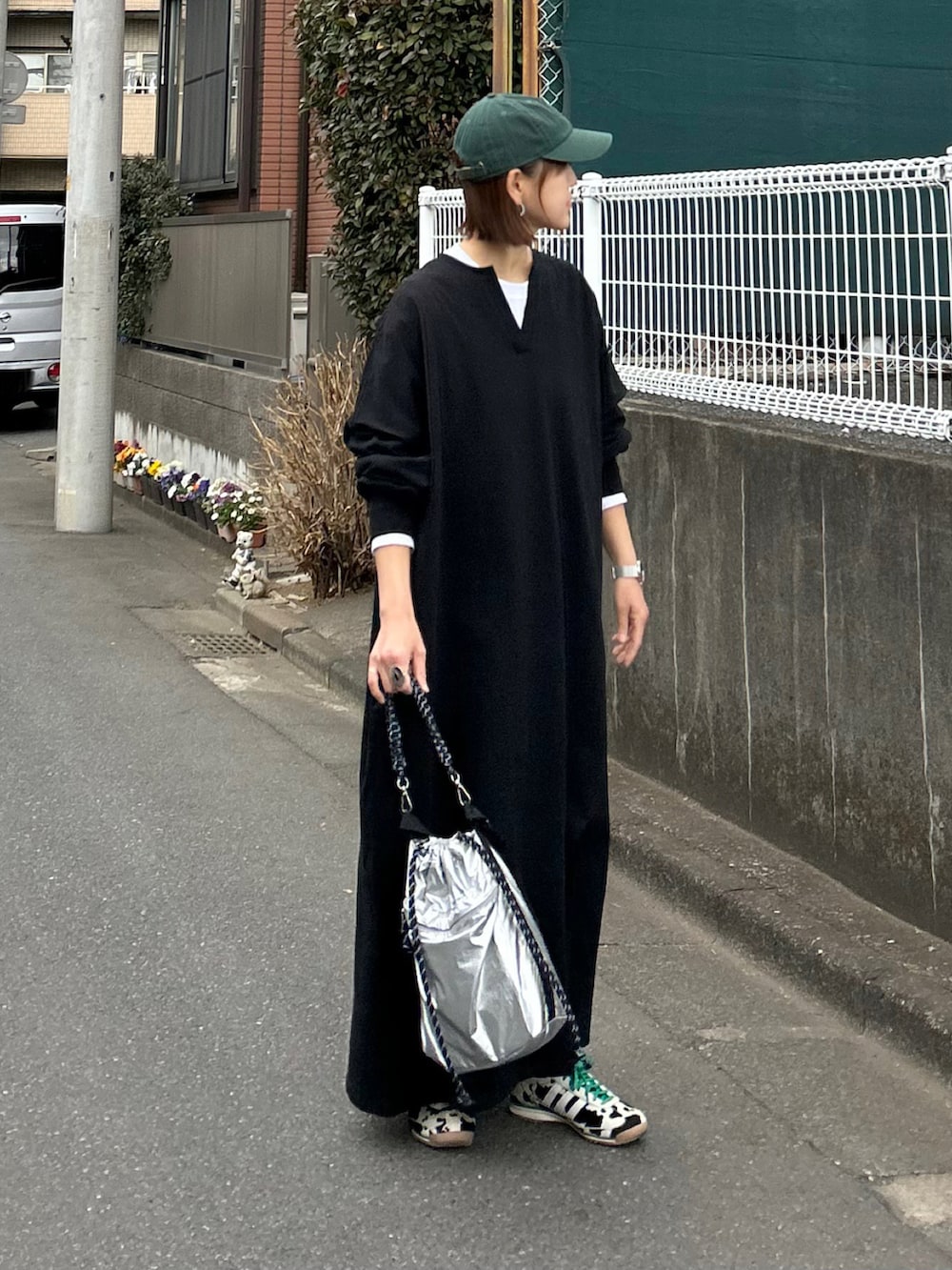 ブラック系のワンピース、シルバー系のトートバッグ、ブラック系のスニーカーを着用したレディースの冬コーディネートの2枚目の写真