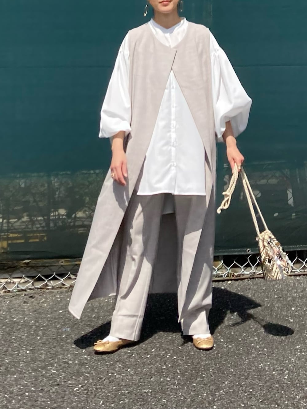 ホワイト系のシャツ/ブラウス、ベージュ系のベスト、ベージュ系のスラックスを着用したレディースの春コーディネートの3枚目の写真