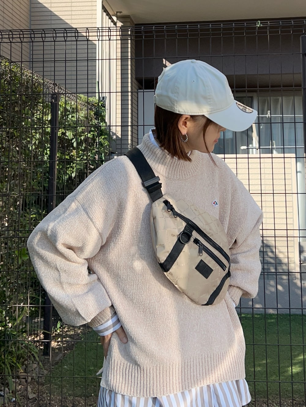 ベージュ系のニット/セーター、ブラウン系のスラックス、ベージュ系のシャツ/ブラウスを着用したレディースの秋コーディネートの2枚目の写真