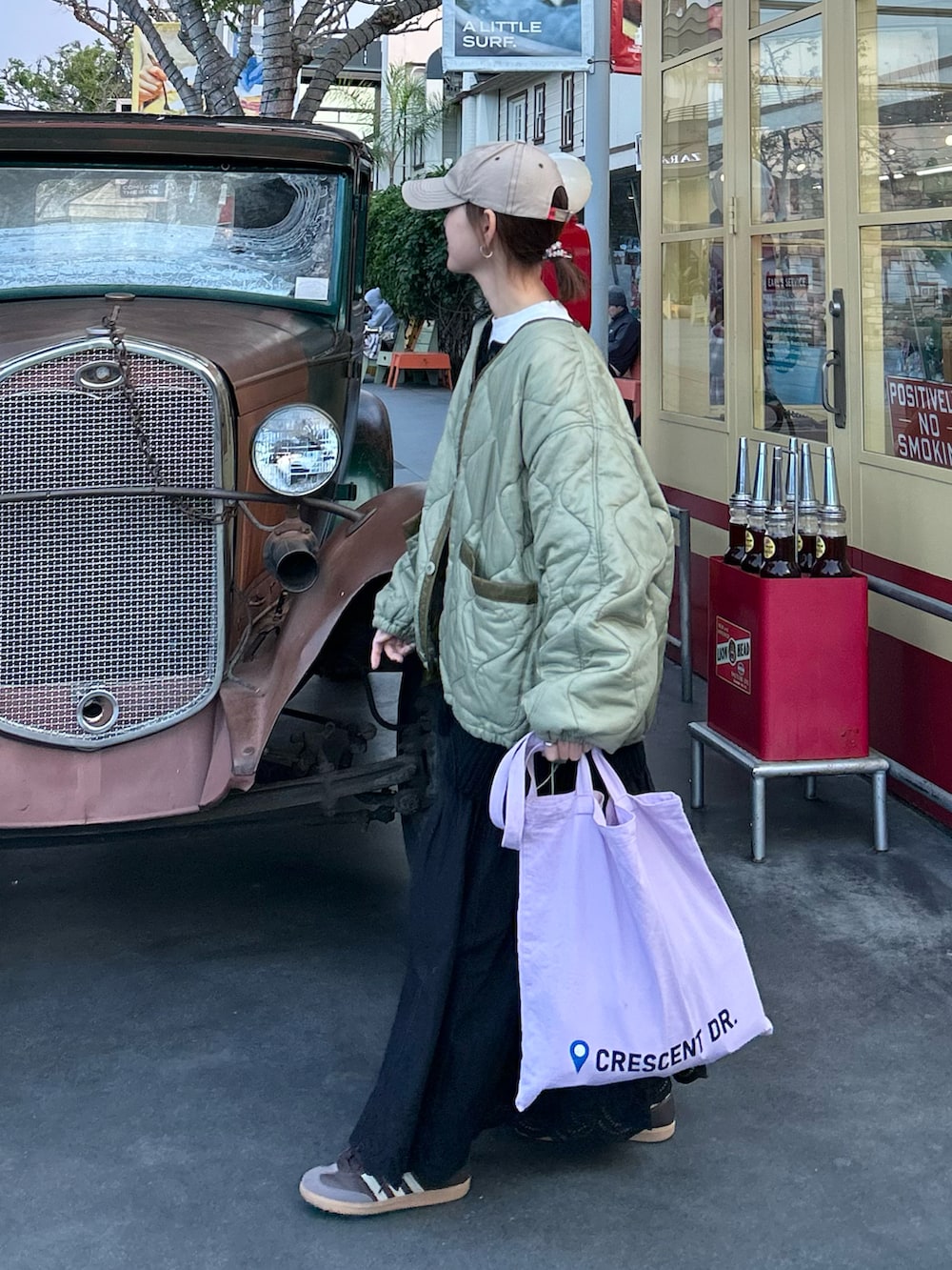 グリーン系のノーカラージャケット、ブラック系のニット/セーター、ブラック系のスカートを着用したレディースの冬コーディネートの2枚目の写真