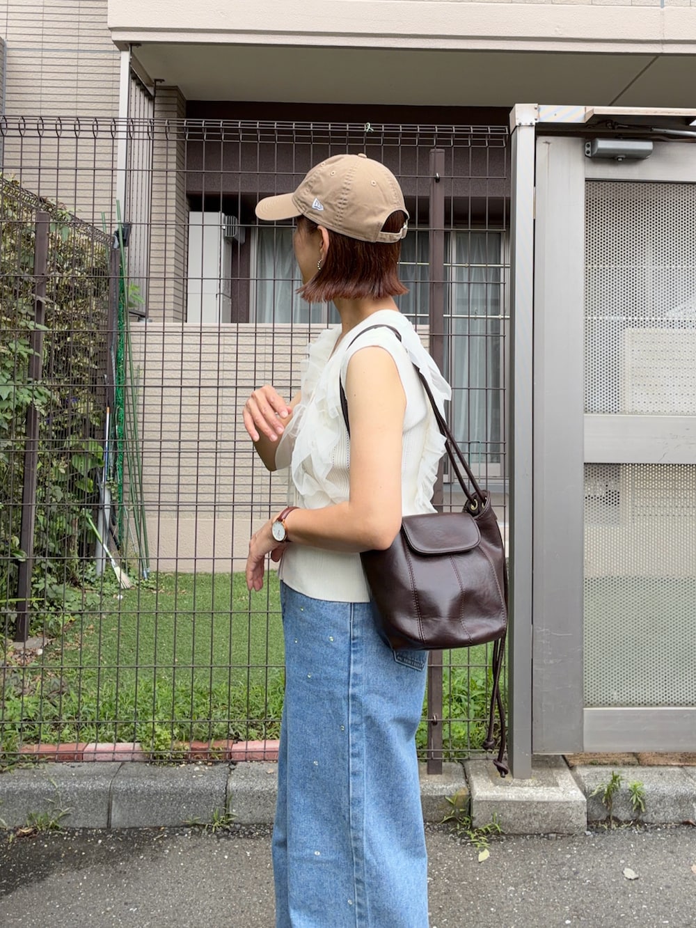 ホワイト系のカーディガン/ボレロ、ブルー系のデニムパンツ、ブラウン系のショルダーバッグを着用したレディースの夏コーディネートの3枚目の写真