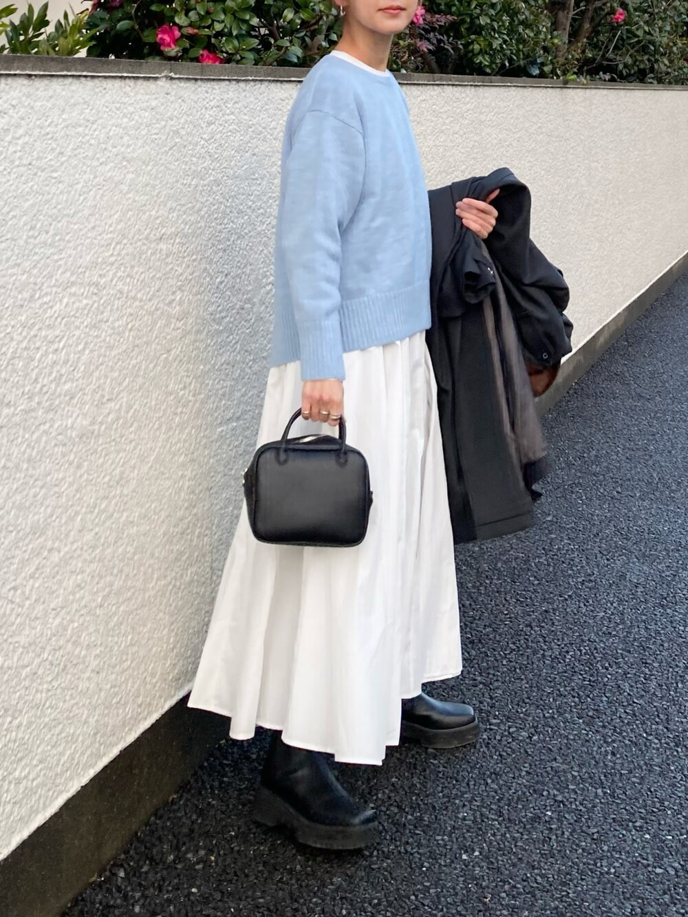 ブルー系のニット/セーター、ホワイト系のシャツワンピース、ブラック系のボストンバッグを着用したレディースの冬コーディネートの3枚目の写真